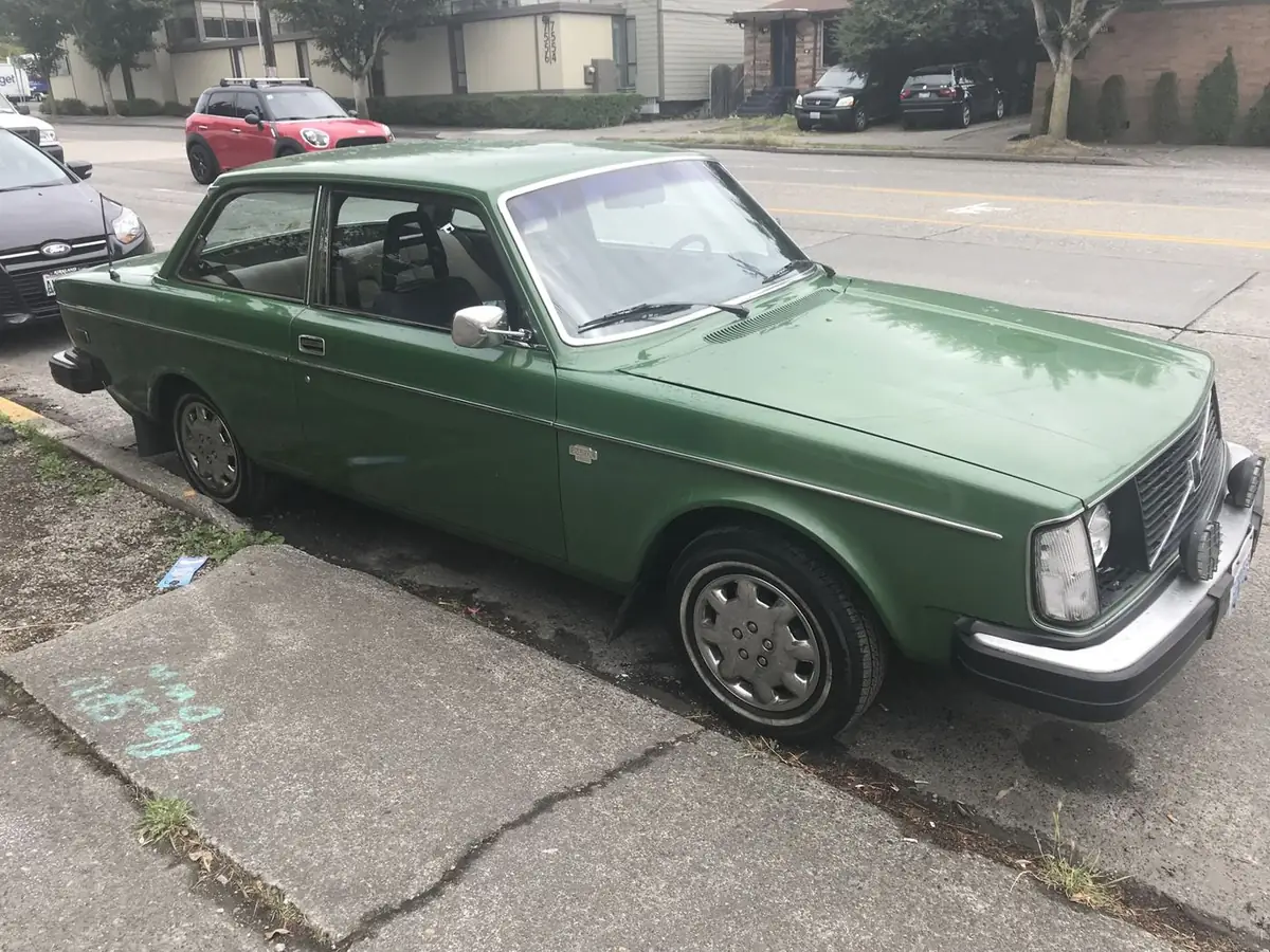 A green two-door Volvo 242